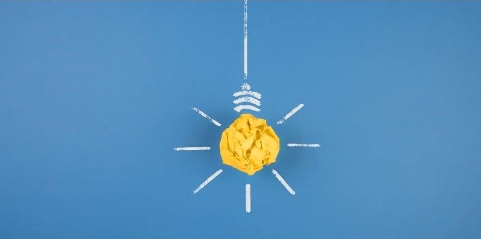 Ilustración de una bombilla de ideas con un foco de inteligencia artificial en el centro.